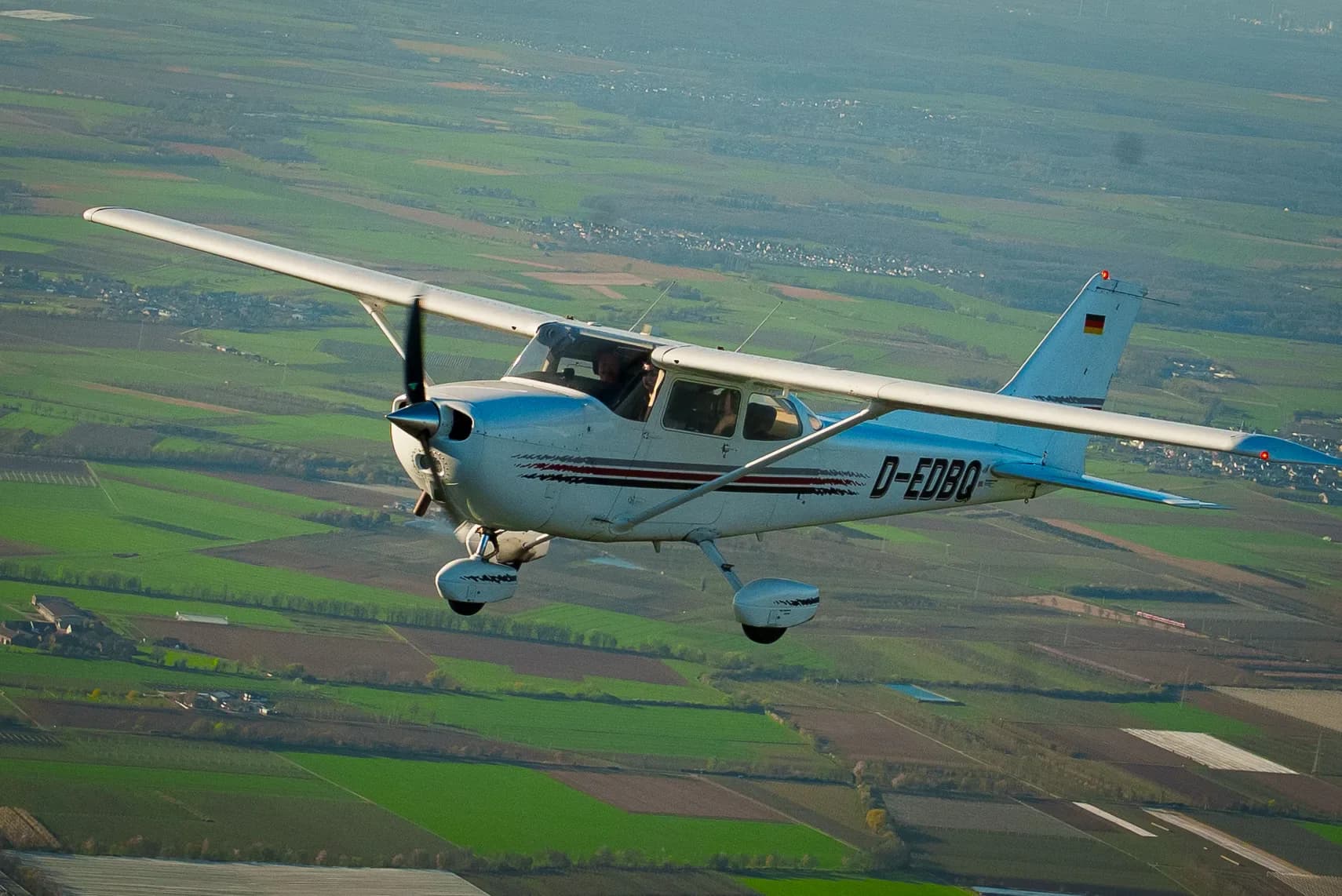 Cessna D-EDBO im Flug über Feldern, aufgenommen aus einem zweiten Flugzeug